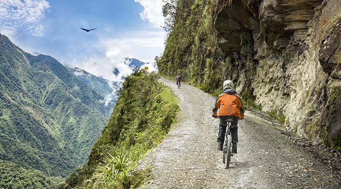 Bike tourists ride on the "road of death" downhill track in Bolivia