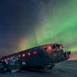 Northern lights over plane wreck on the black beach in Vik
